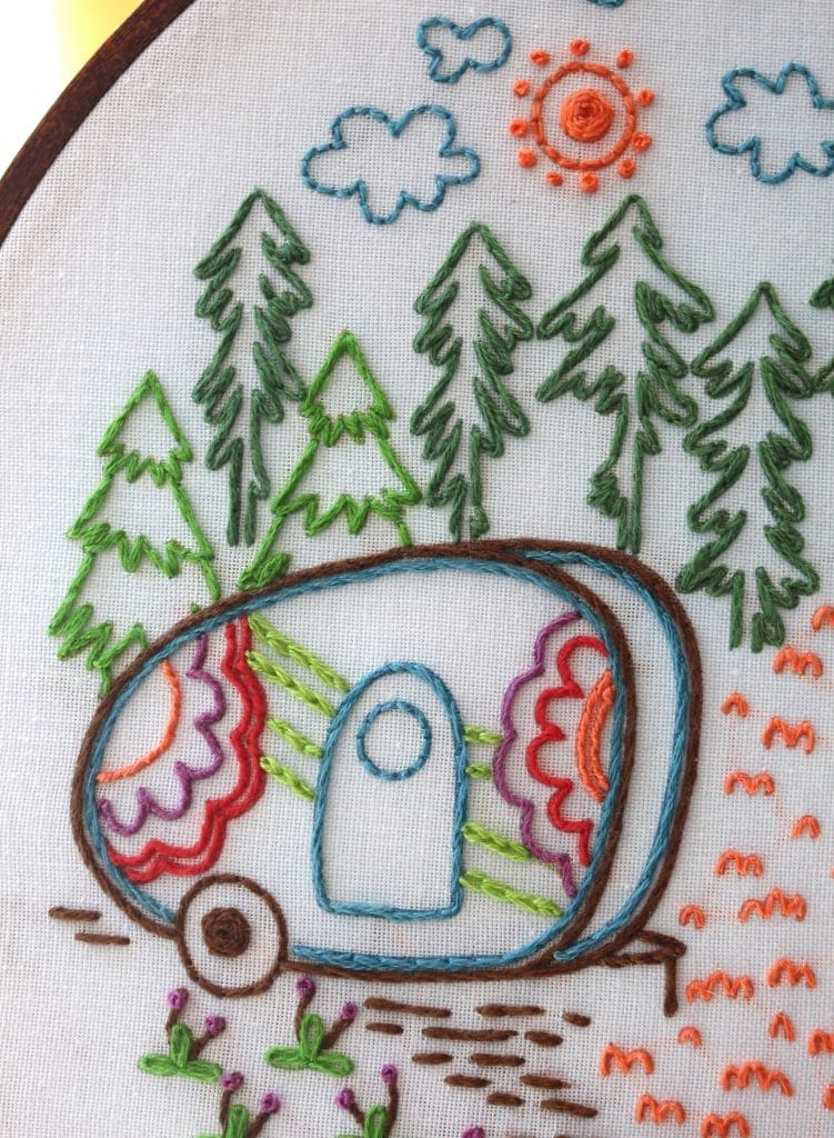 See French Knots on To The Woods surrounding the sun and topping the little flower stems below the camper van.