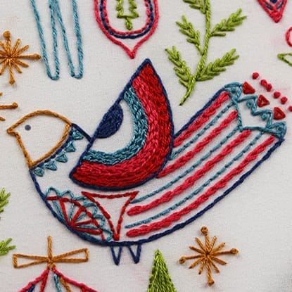The wing of this bird in Holiday Folk is partially filled with several rows of chain stitch. 