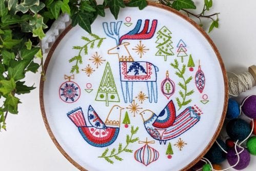 folk art-inspired holiday embroidery pattern with reindeer, trees and birds. 