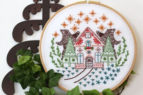 winter themed embroidery kit with bears dancing under the starlit sky and a gingerbread house