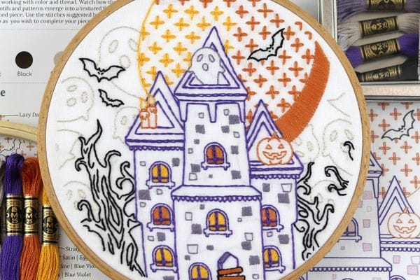 embroidery project with ghosts and bats in front of a spooky haunted mansion