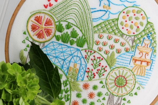 embroidery project with rolling hills, greenhouse and orchards