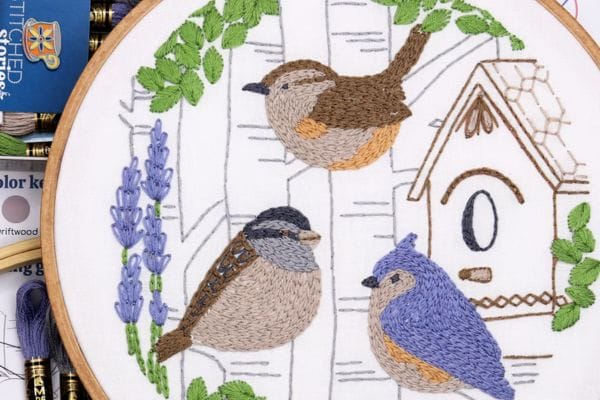 Embroidered hoop art of birds, trees and birdhouse