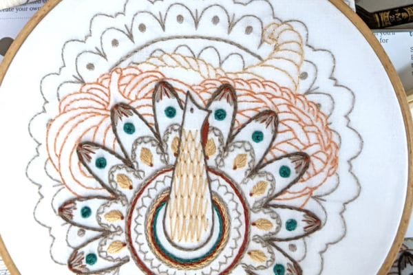 Embroidered hoop-art of turkey in Harvest Table.