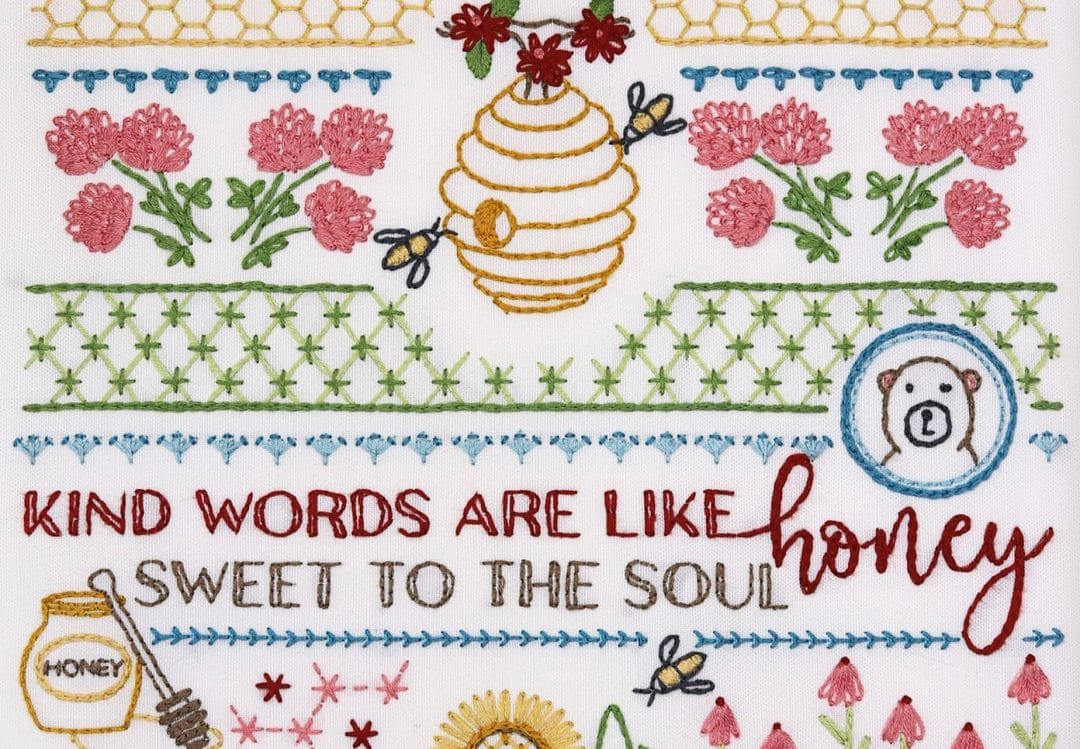 Embroidered detail from traditional embroidery stitch sampler with honeybee themes