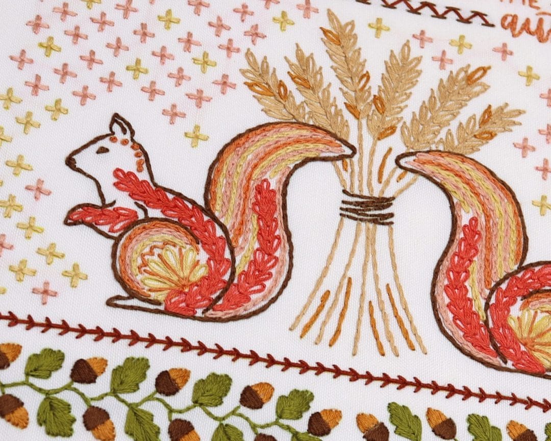 Embroidered detail from traditional embroidery stitch sampler with fall themes