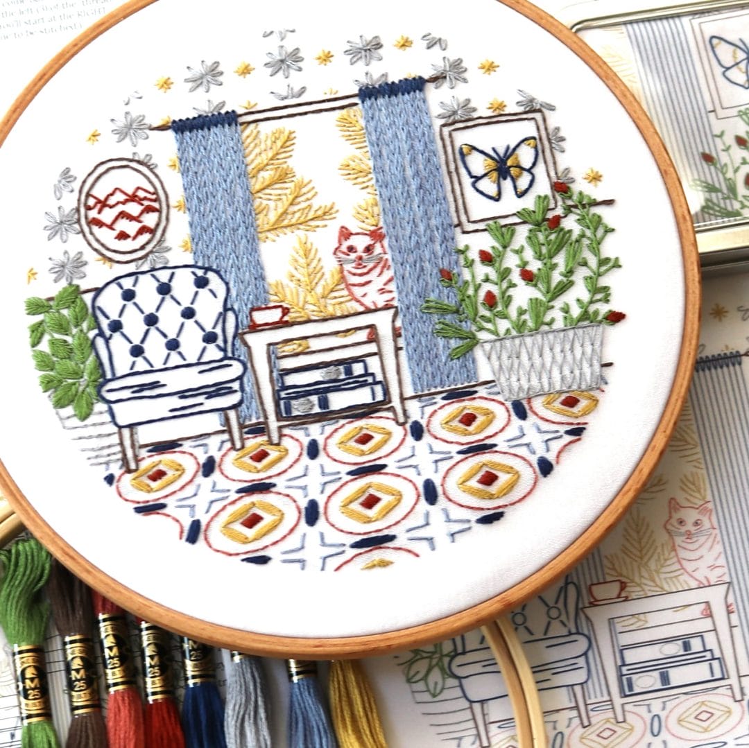 Home-themed embroider hoop art with interior scene.