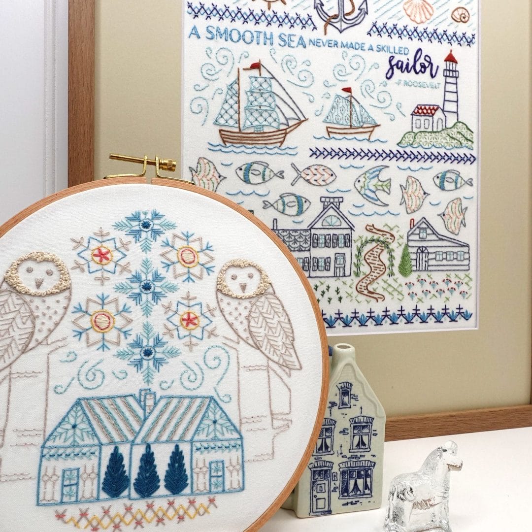 styled vignette with beach-themed embroidery sampler and wintery owl hoop art.