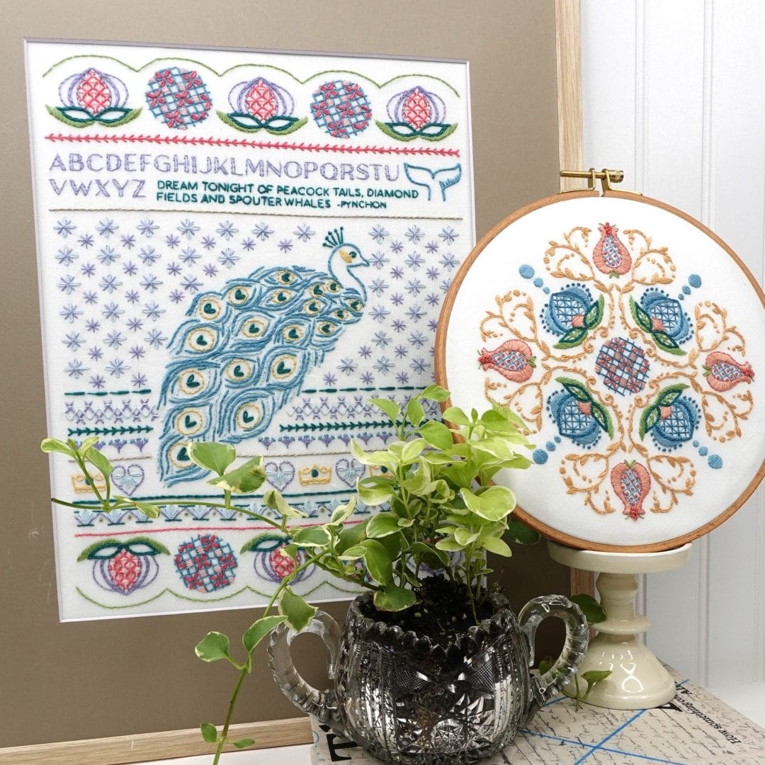 styled vignette featuring peack-themed embroidery sampler and jacobean embroidery hoop