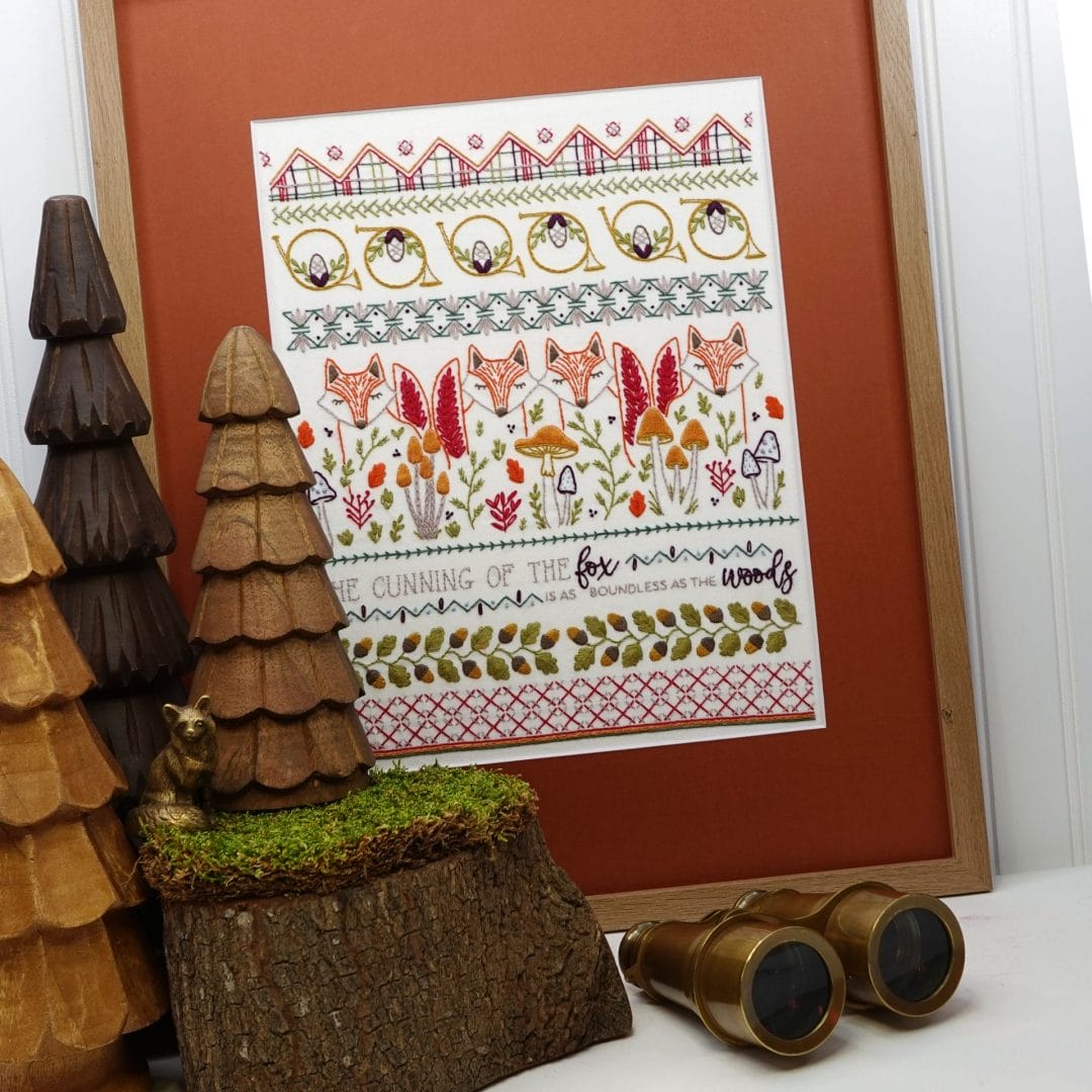 Framed Foxes and Horns embroidery sampler on display.